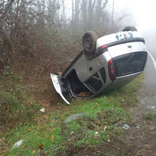 Perde il controllo dell'auto e si ribalta in un fosso