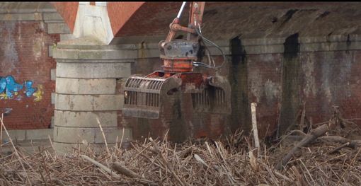 La rimozione del legname finito contro le arcate del ponte La rimozione del legname finito contro le arcate del ponte