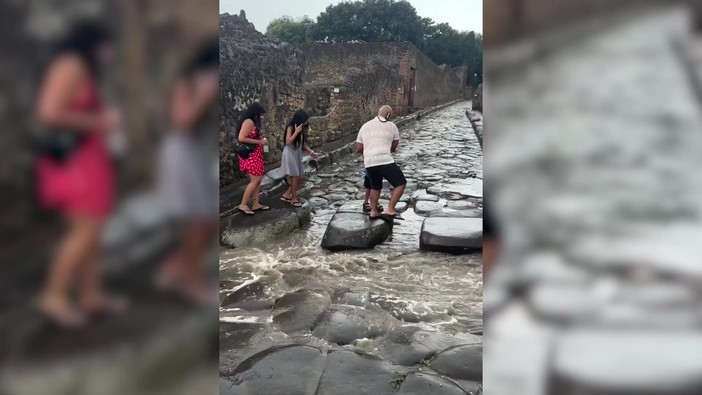 Acquazzone su Pompei, turisti usano le antiche strisce pedonali dei romani